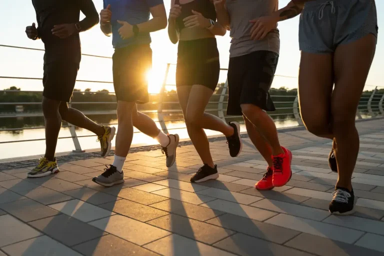Grupo de corredores entrenando juntos al atardecer junto al río